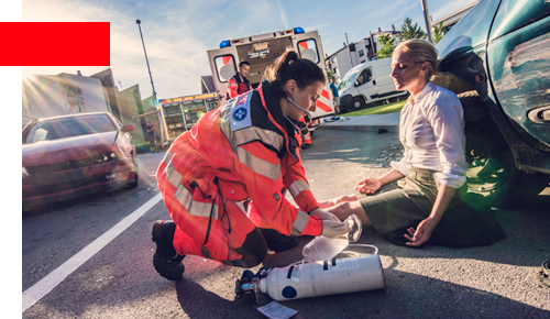 Accident scene with female paramedic treating a woman